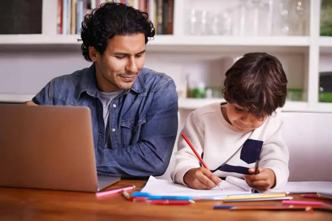 Rodzic pomaga dziecku w nauce zdalnej