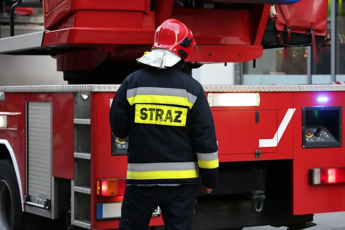 Strażak w hełmie i kurtce z napisem 