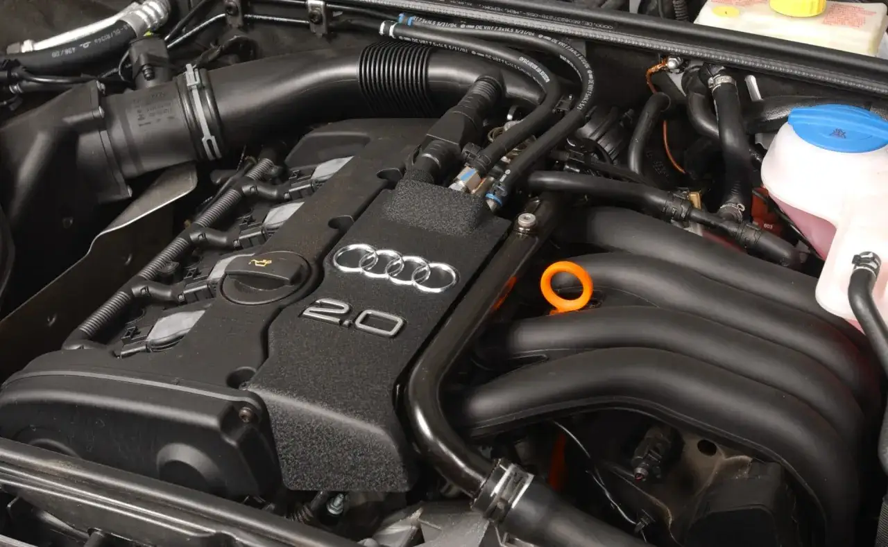 Silnik Audi 2.0 TFSI, przykład niezniszczalnych silników benzynowych, z widocznymi elementami układu dolotowego i chłodzenia.