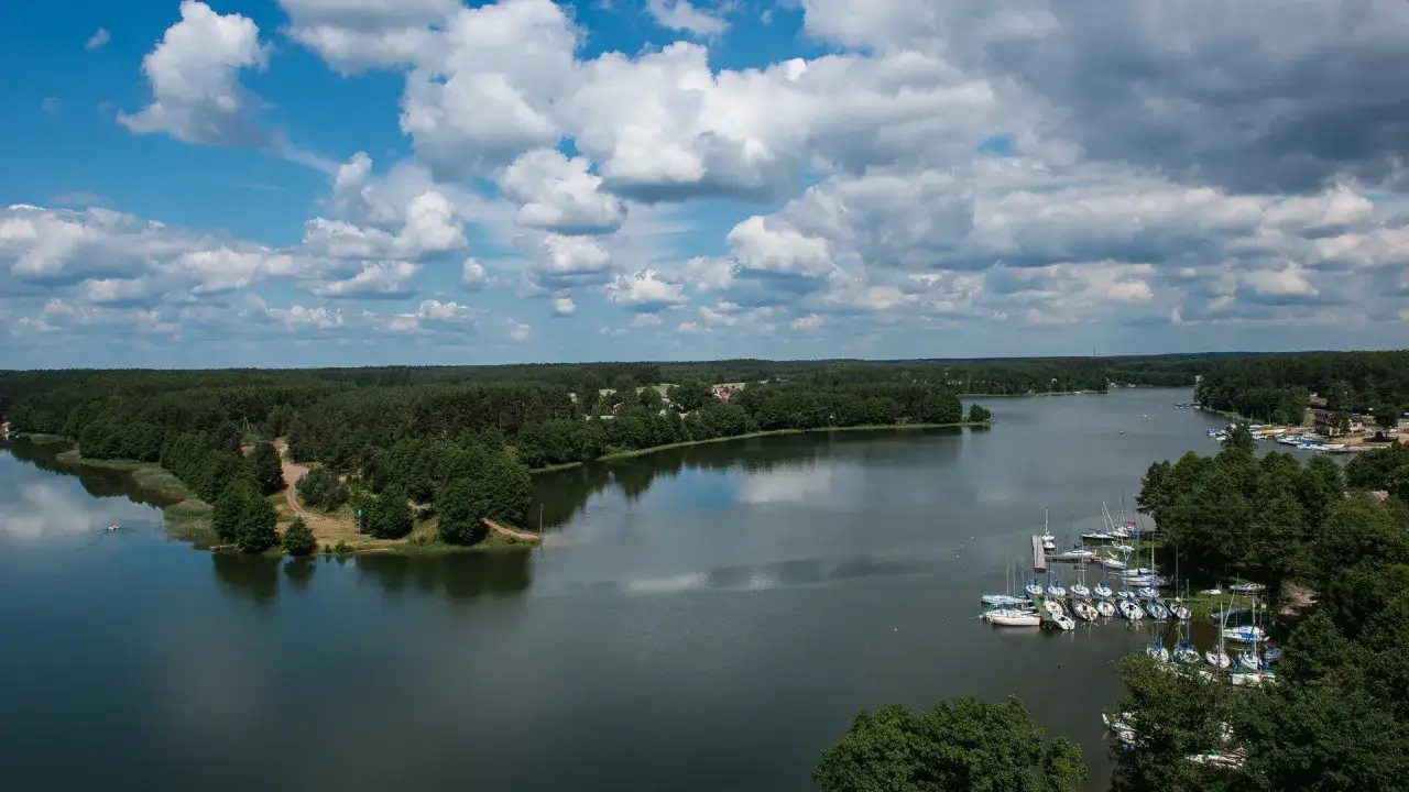 Malownicze jezioro z żaglówkami, otoczone lasem. Idealne miejsce na relaks w hotelu spa Kaszuby.