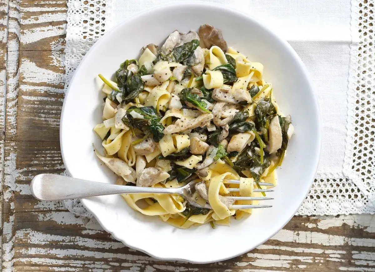 Tagliatelle z boczniakami i szpinakiem, polane kremowym sosem. Pyszne danie, kt&oacute;re zachwyci każdego miłośnika grzyb&oacute;w.