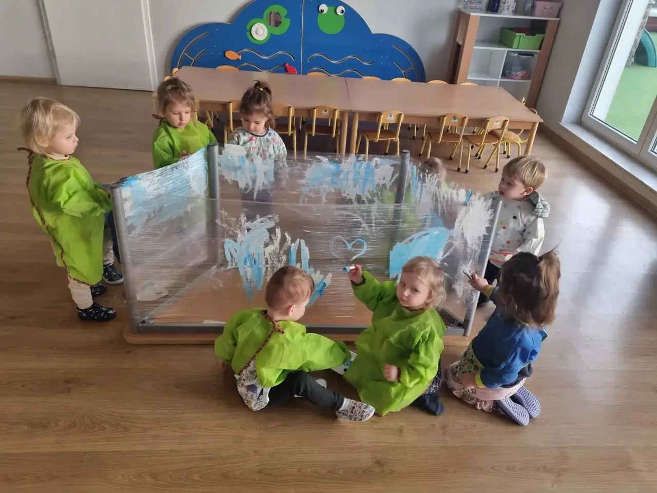 Dzieci w fartuszkach malują na folii. Tak wygląda żłobek pełen kreatywności i zabawy.