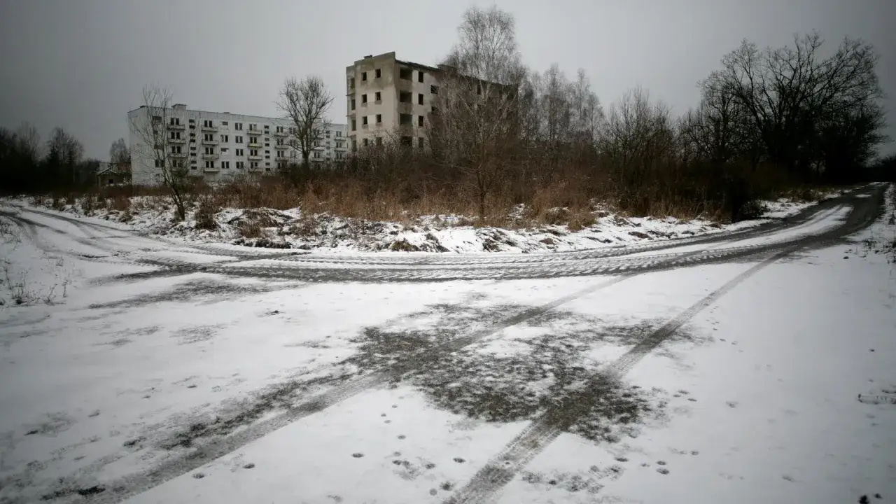 Opuszczone miasta w Polsce. Zima otula śniegiem puste bloki i zarośnięte drogi, tworząc ponury krajobraz.