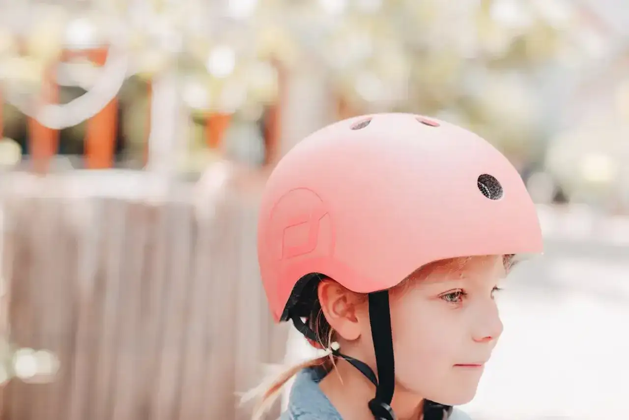 Dziewczynka w r&oacute;żowym kasku rowerowym, gotowa na przygodę.