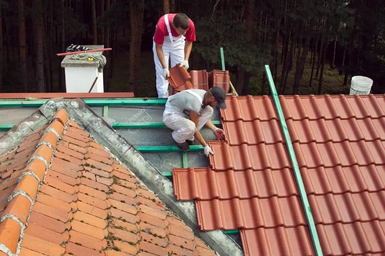 Dwaj dekarze układają nowe dachówki. Zastanawiasz się, ile dachówek wchodzi na m2?