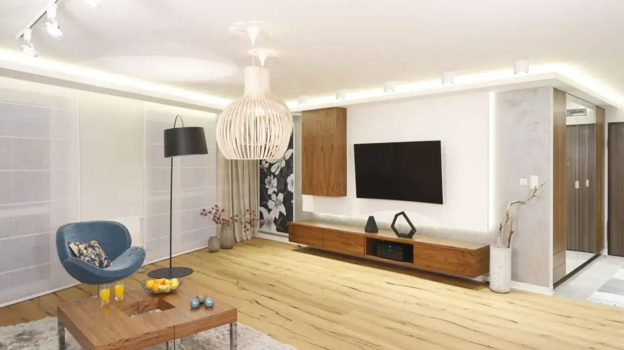 telewizor powieszony na ścianie nad szafką rtv