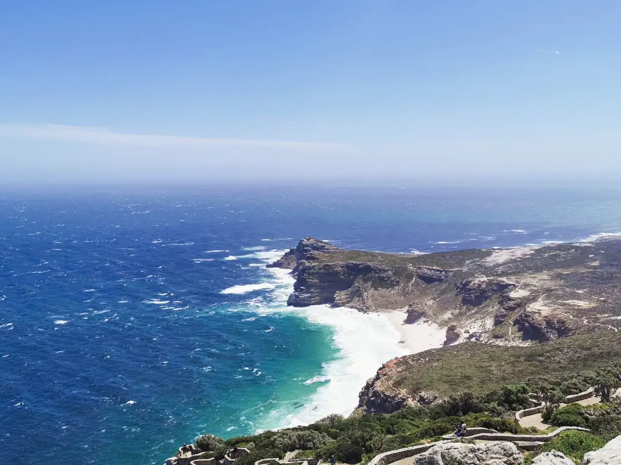 Widok na skaliste wybrzeże i turkusowe morze z punktu widokowego na Przylądku Dobrej Nadziei.