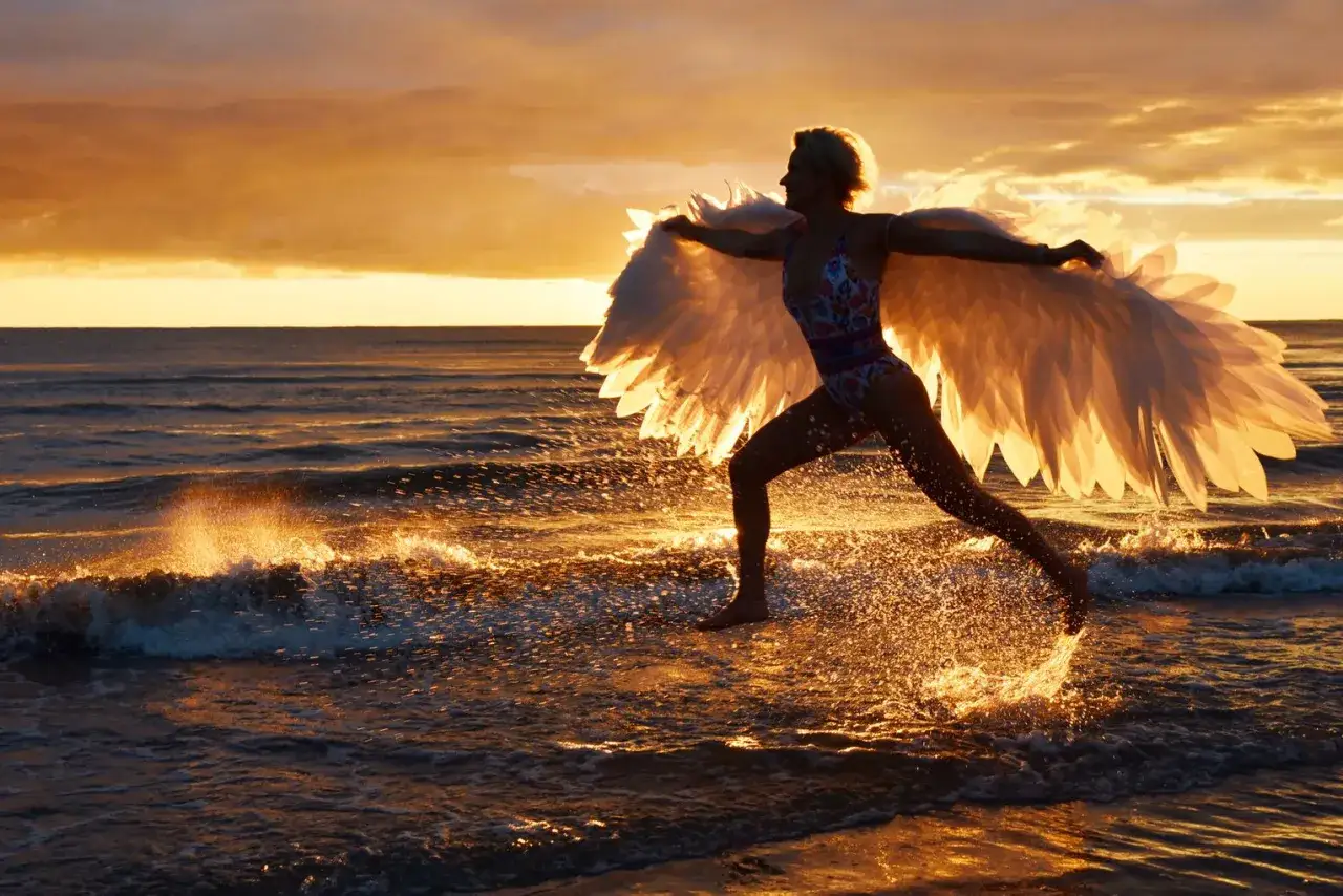 Osoba robiąca zdjęcie zachodu słońca na plaży z telefonem