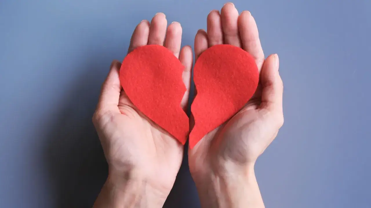Dwie dłonie trzymają poł&oacute;wki czerwonego serca. Zastanawiasz się, co napisać byłemu, żeby odpisał?