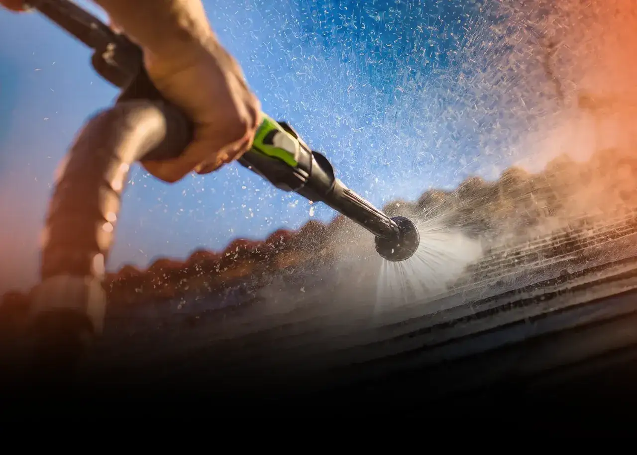 Dłoń trzymająca lancę myjki Karcher, która rozpyla wodę na dach. Zastanawiasz się, dlaczego zostają smugi po myjce Karcher?