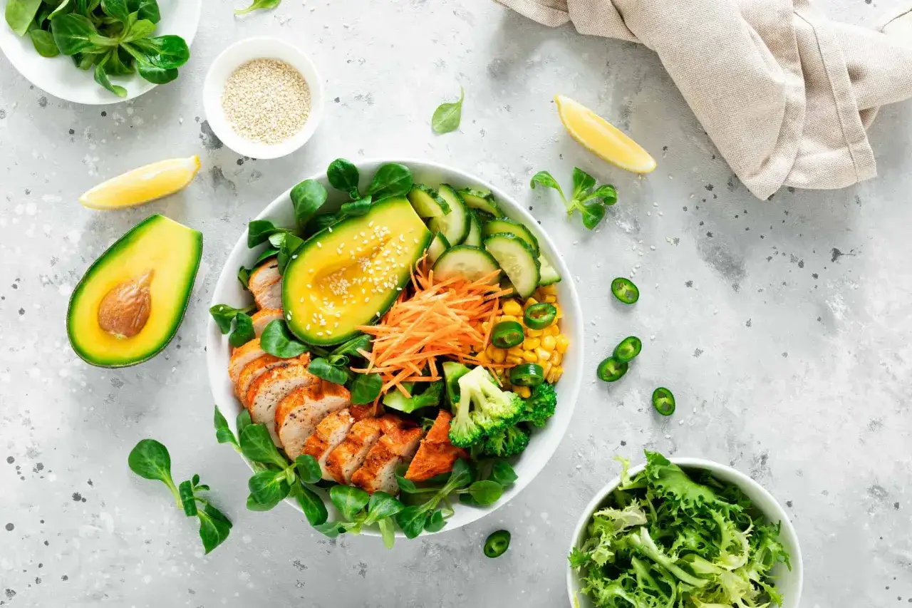 Zdrowa buddha bowl z kurczakiem, awokado, kukurydzą, brokułami i marchewką. Idealny posiłek na szybki lunch.
