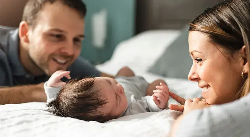 młodzi rodzice z noworodkiem przeglądający dokumenty