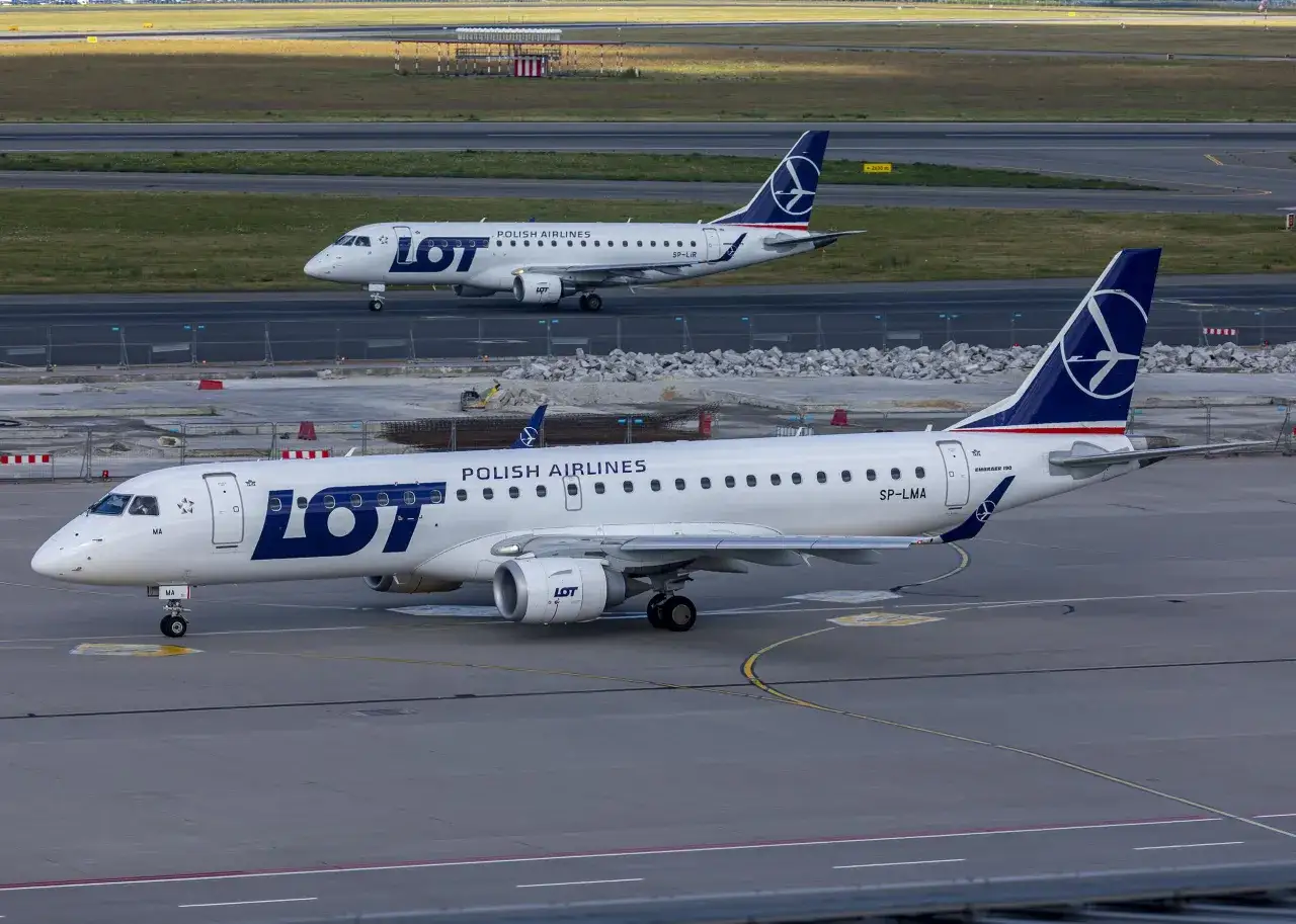 Dwa samoloty LOT Polish Airlines na płycie lotniska. Zastanawiasz się, jak daleko jest Dubaj od Polski?