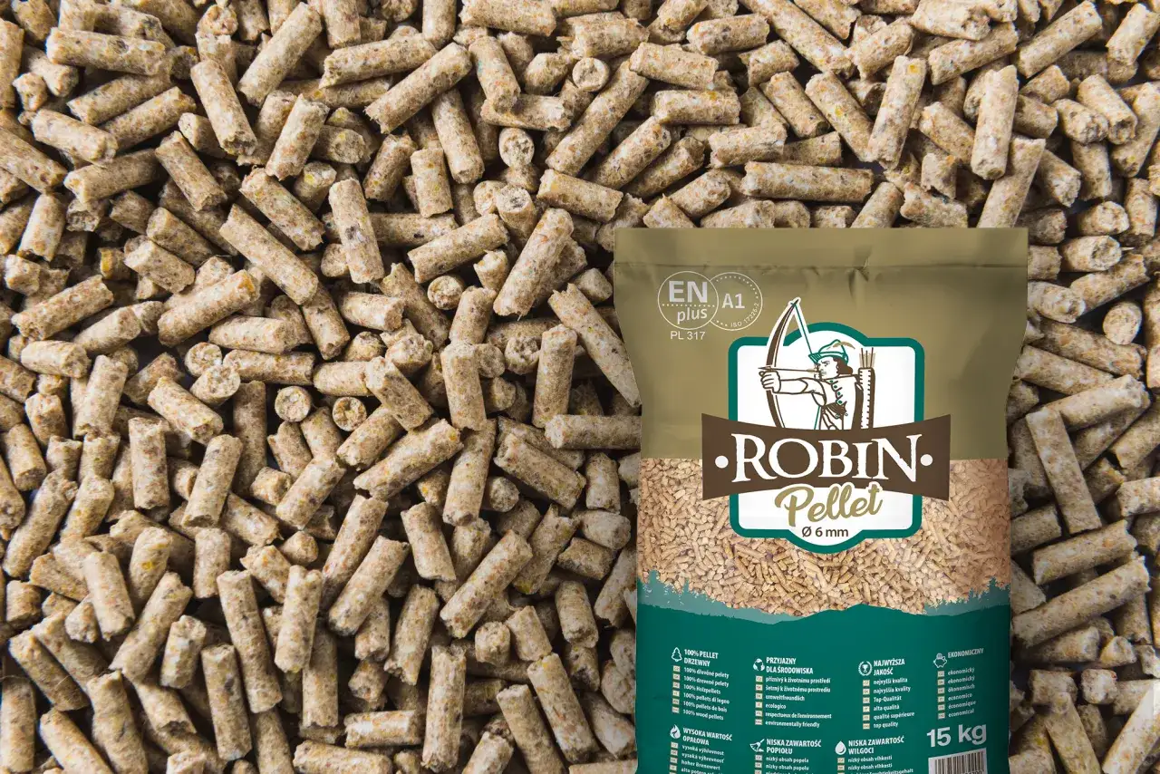 Zbliżenie na pellet drzewny, który wygląda jak małe, cylindryczne granulki. Torba z logo 