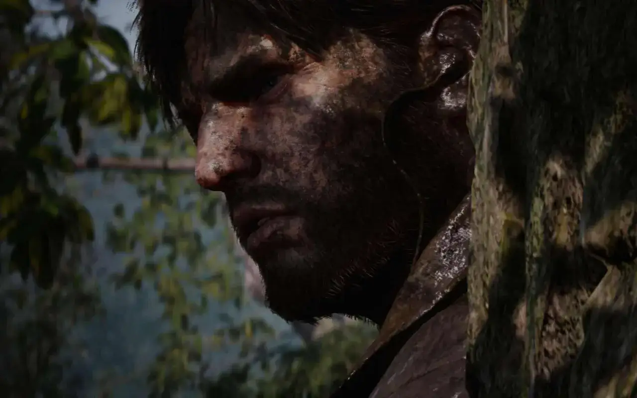 Twarz Snake'a, pokryta błotem, ukryta za drzewem. Zapowiada się kolejna misja w Metal Gear Solid Delta.