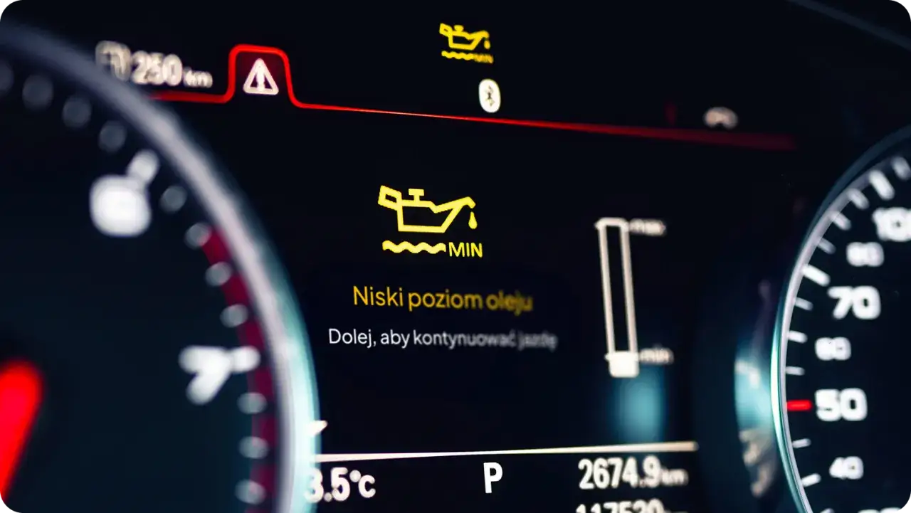 Na desce rozdzielczej świeci się kontrolka niskie ciśnienie oleju. Trzeba dolać, by kontynuować jazdę.