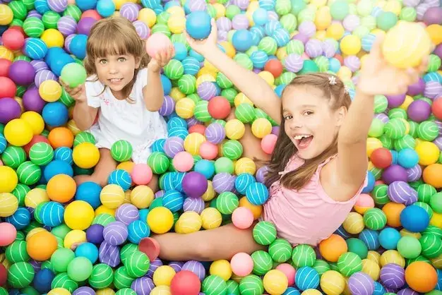dzieci bawiące się w kolorowej sali zabaw z kulkami