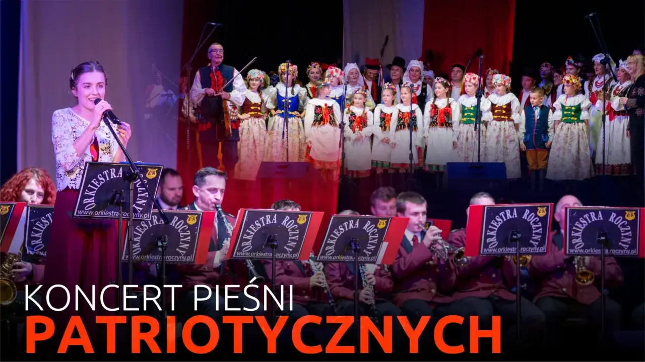 Młoda wokalistka i dzieci w strojach ludowych śpiewają piosenki o Polsce. Orkiestra gra patriotycznie.