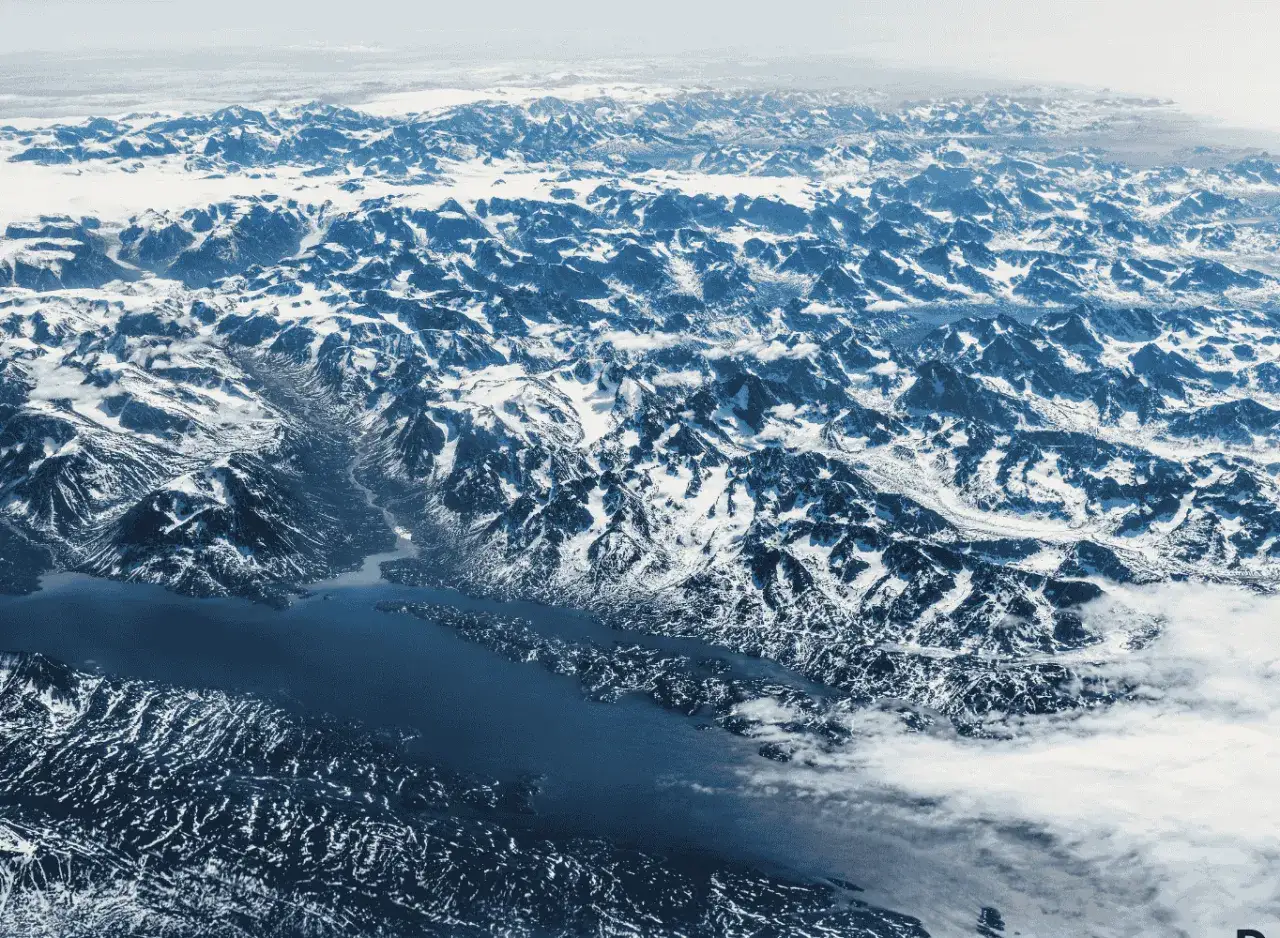 Krajobraz górski pokryty śniegiem, z wodą wcinającą się między szczyty. Trudno określić, ile jest wysp na ziemi, patrząc na ten widok.