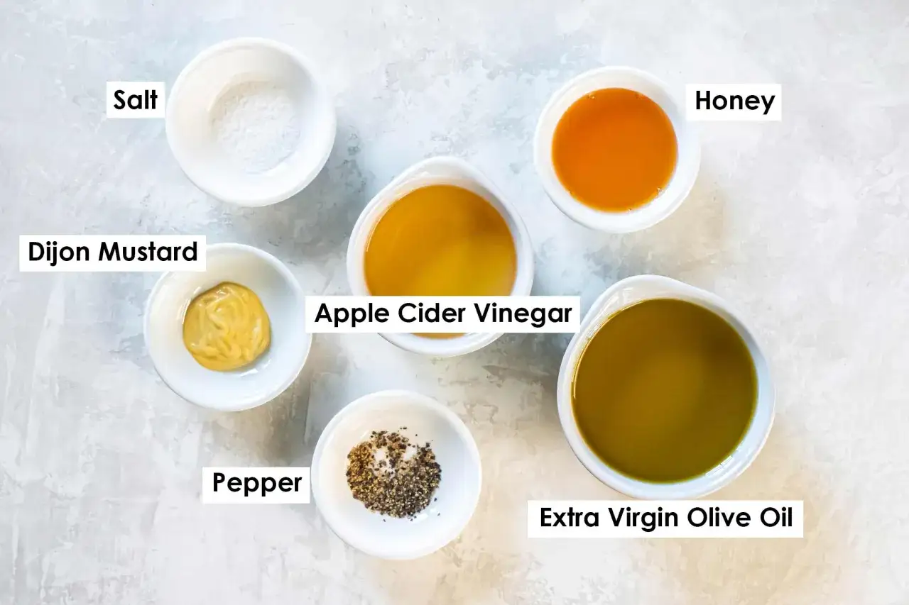 Składniki do sosu winegret: oliwa z oliwek, ocet jabłkowy, musztarda Dijon, mi&oacute;d, s&oacute;l i pieprz. Prosty przepis na pyszny dressing.