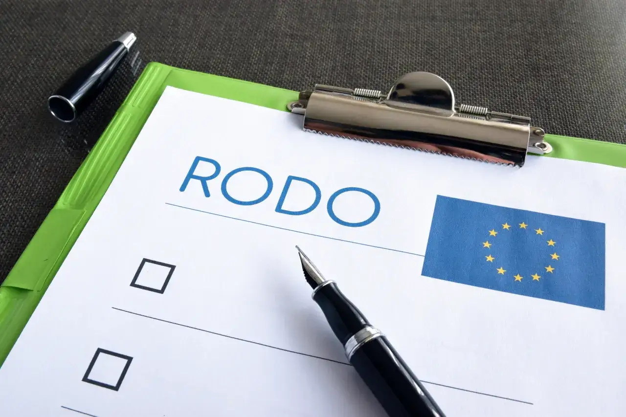 Dokument z napisem RODO i flagą UE. Pytanie: skąd firma windykacyjna ma mój numer telefonu? Długopis i pióro.