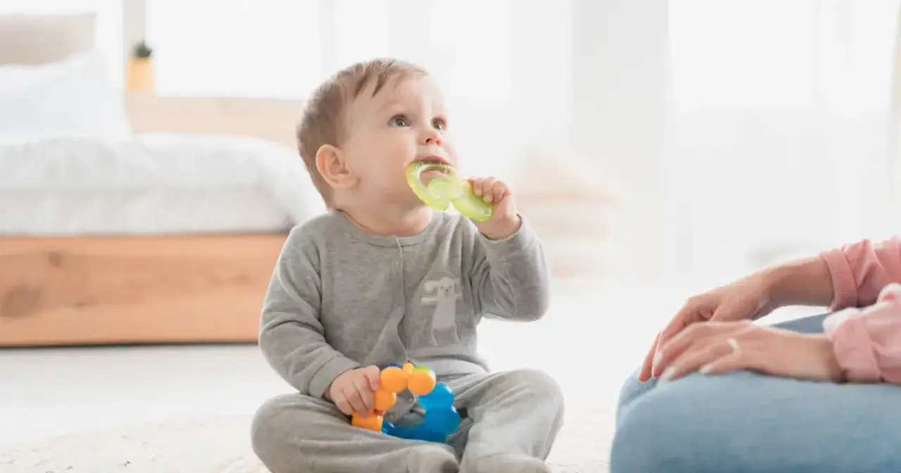 Maluch gryzie gryzak, szukając ulgi przy ząbkowaniu. To jeden ze sposobów, jak pomóc dziecku przy ząbkowaniu.