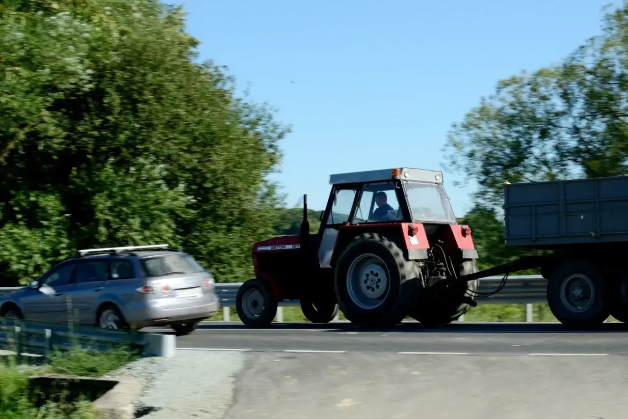 Ciągnik Zetor z przyczepą jedzie po drodze. Czy na kat B można jeździć ciągnikiem z przyczepą?