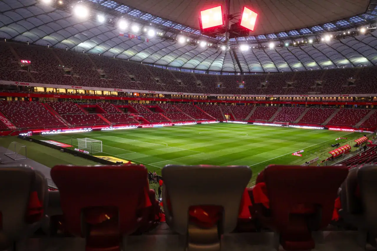 Puste trybuny stadionu, zielona murawa i bramka czekają na emocje, kiedy liga mistrzów 2026 zawita do Polski.