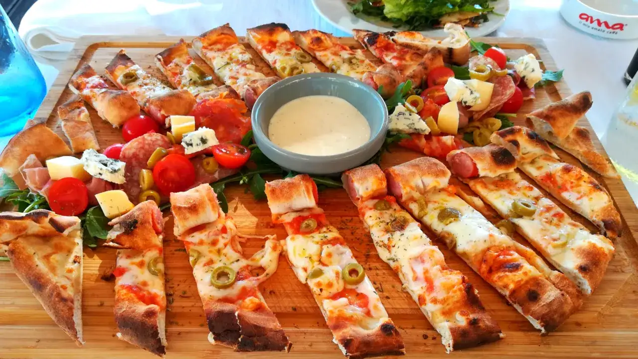 Pyszna pizza, wędliny, sery i sos. Zastanawiasz się, ile kosztuje jedzenie w Albanii? Taka uczta to świetny pomysł na wakacje!