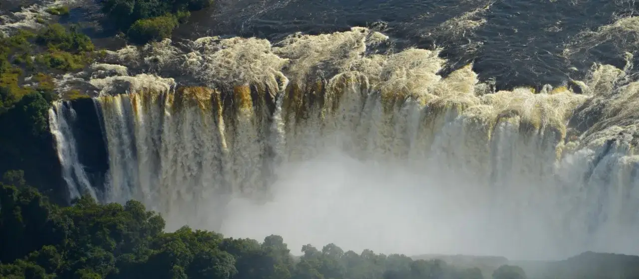 Potężne Wodospady Wiktorii, jedne z największych atrakcji Zimbabwe, tworzą mgłę i huk.
