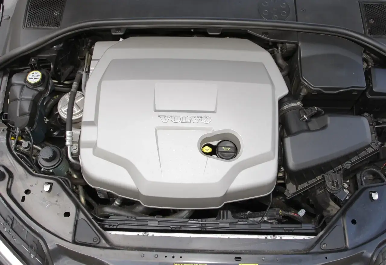 Silnik Volvo pod srebrną osłoną z logo. Trudno jednoznacznie stwierdzić, które silniki Volvo są najlepsze, ale ten wygląda na zadbany.
