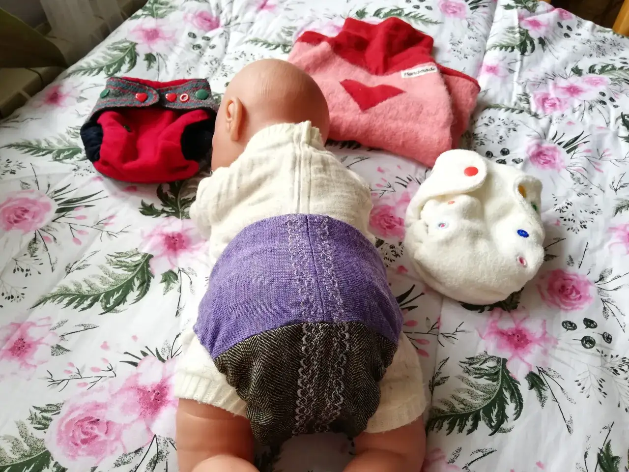 Lalka w pieluchach wielorazowych. Ile pieluch dziennie dla noworodka? Zależy od dziecka i pieluch.