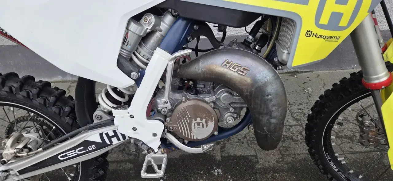 Silnik i wydech HGS motocykla Husqvarna WR 125. Widoczny amortyzator WP XACT i opona terenowa.