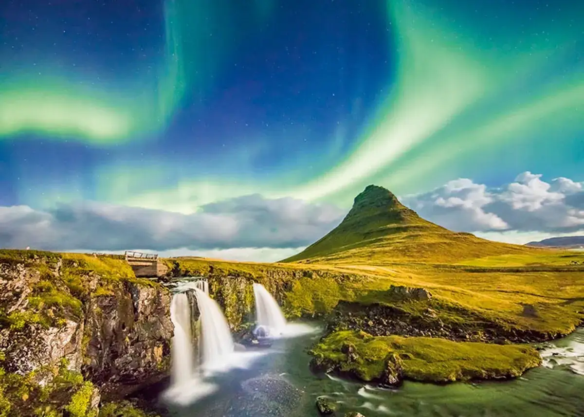 Wodospady i góra Kirkjufell pod zorzą polarną. Idealne miejsce, by zastanowić się, kiedy lecieć na Islandię.