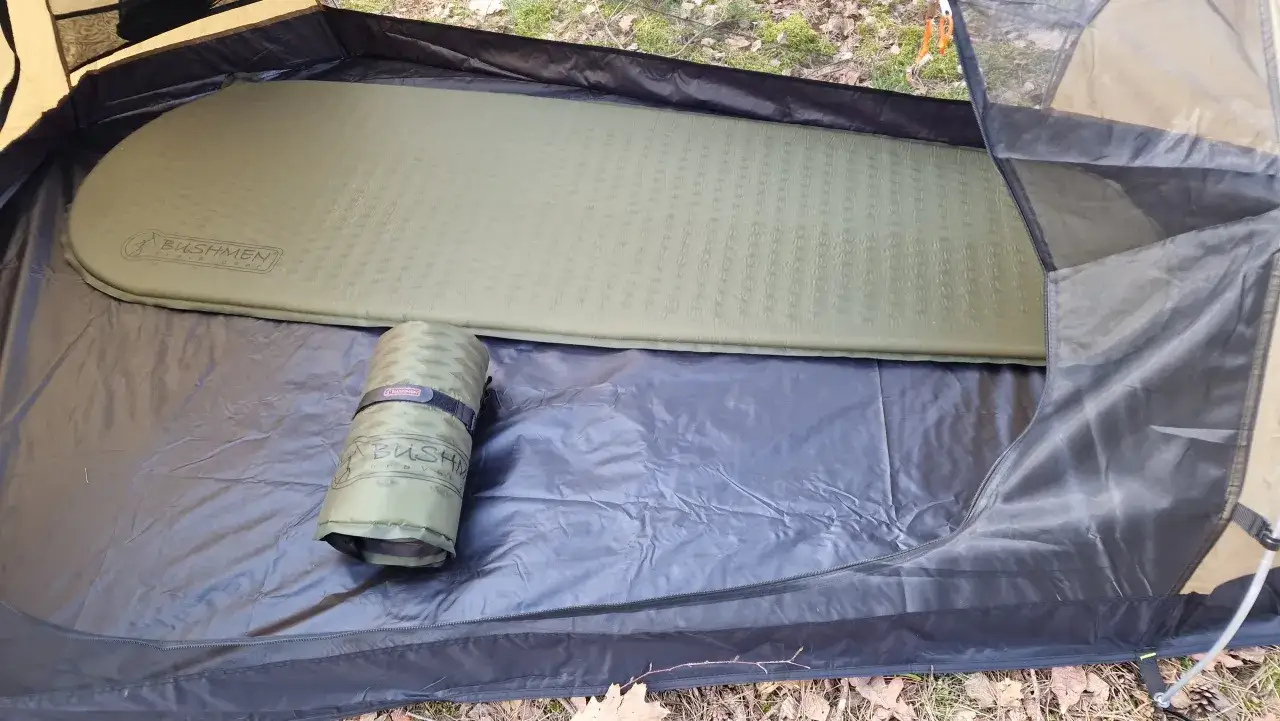 Rozłożony materac samopompujący w namiocie. Zwijanie go to pierwszy krok, jak napompować materac samopompujący.