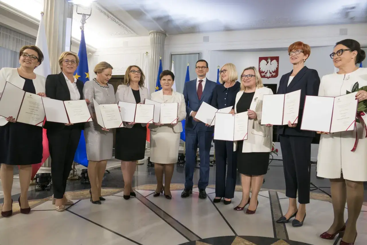 Grupa osób, w tym premier Mateusz Morawiecki, prezentuje dokumenty. Wśród nich są polscy europosłowie, którzy otrzymali nominacje.