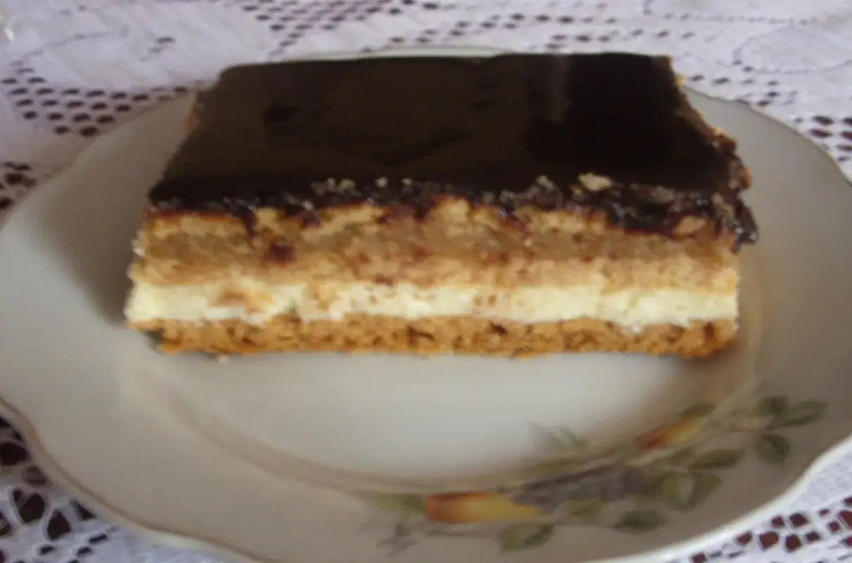 Pyszny kawałek ciasta z warstwami serowo-jabłkowymi i polewą czekoladową. Idealny przepis na ciasto delicja z serem i jabłkami.