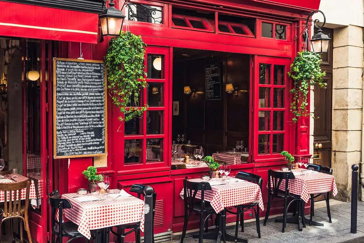 Urocza kawiarnia w 6 dzielnicy Paryża. Czerwona fasada, stoliki w kratkę i wiszące bluszcze tworzą paryski klimat.