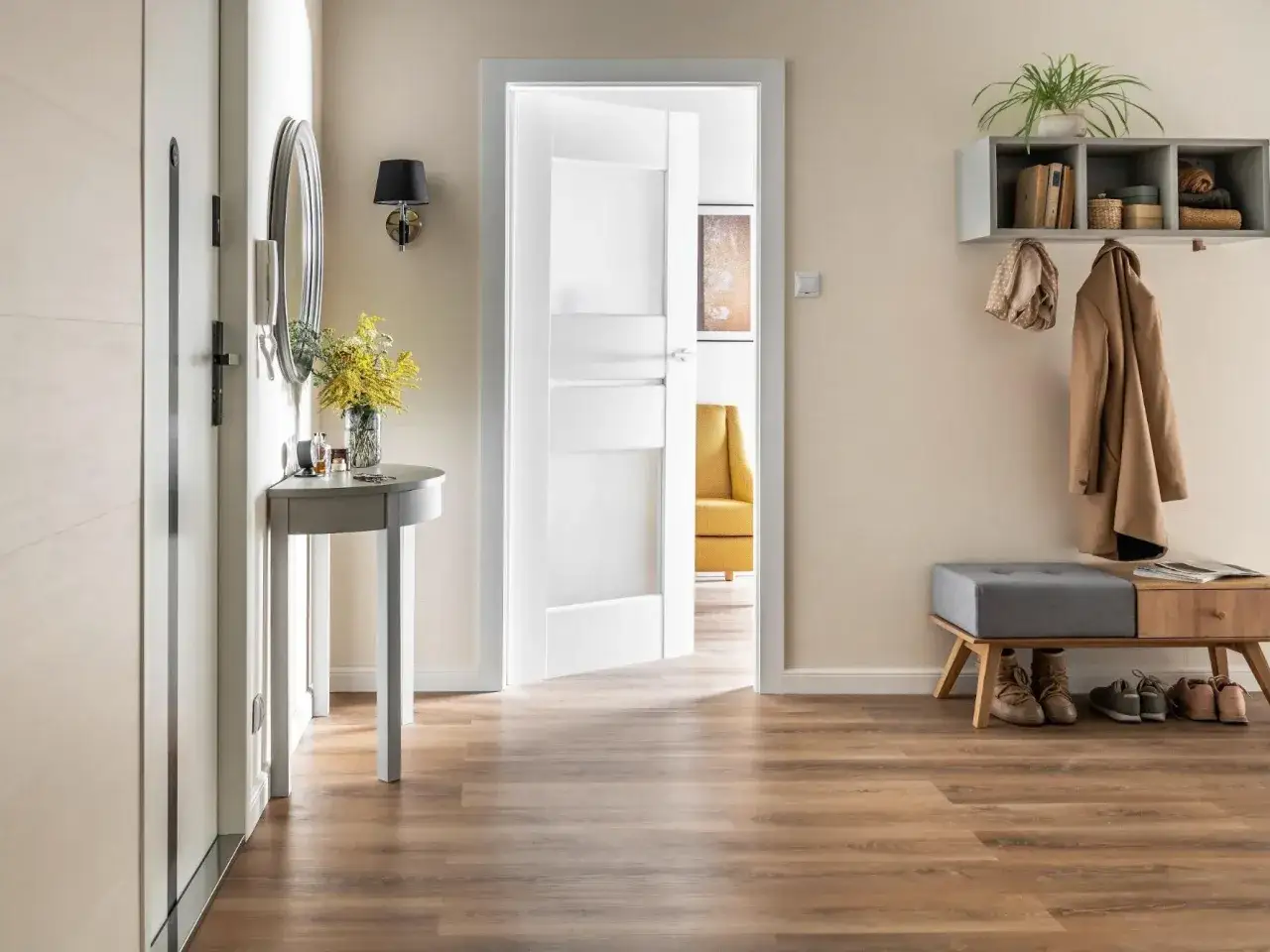 Jasny przedpokój z konsolką, lustrem i półką na płaszcze. Świetny pomysł na ścianę w przedpokoju, który doda elegancji.