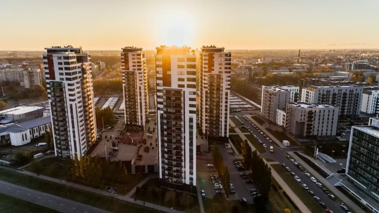 Nowoczesne wieżowce w blasku zachodzącego słońca. Inwestycja objęta deweloperskim funduszem gwarancyjnym.