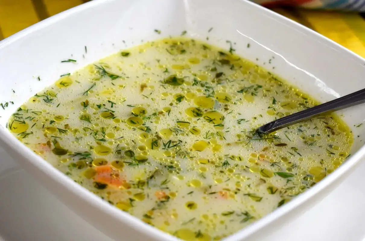 Aromatyczna zupa ogórkowa bez mięsa, pełna koperku i kawałków warzyw, pływająca w kremowym wywarze.