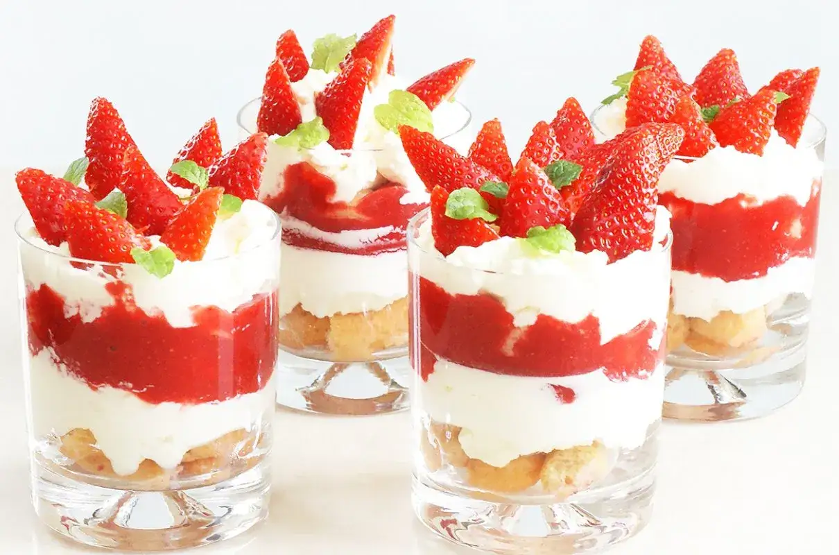 Tiramisu klasyczne kontra tiramisu truskawkowe. W szklankach warstwy biszkoptów, kremu, musu truskawkowego i świeżych owoców.