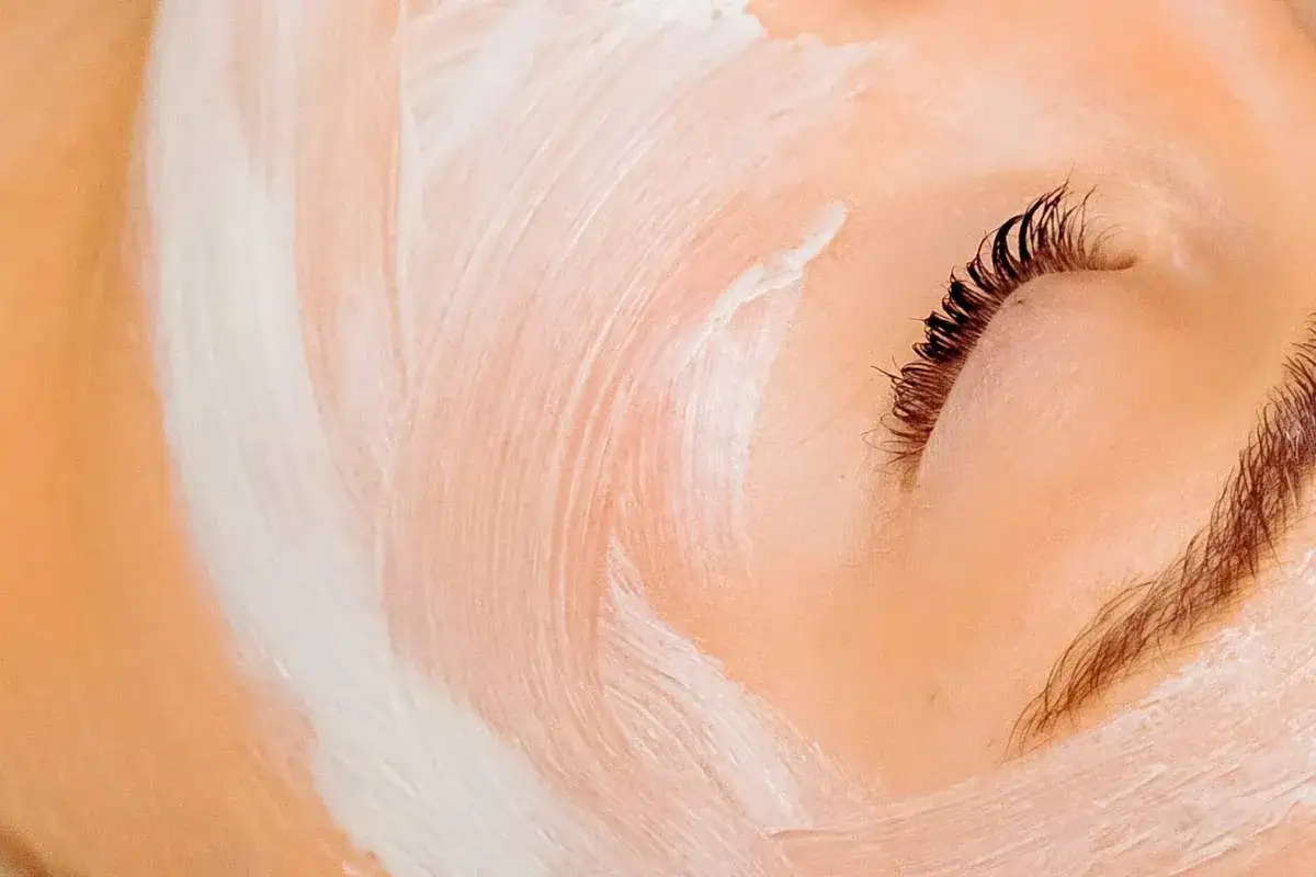 Delikatna maść tranowa na twarz otula sk&oacute;rę, tworząc kojący kompres. Widać zamknięte oko z długimi rzęsami.