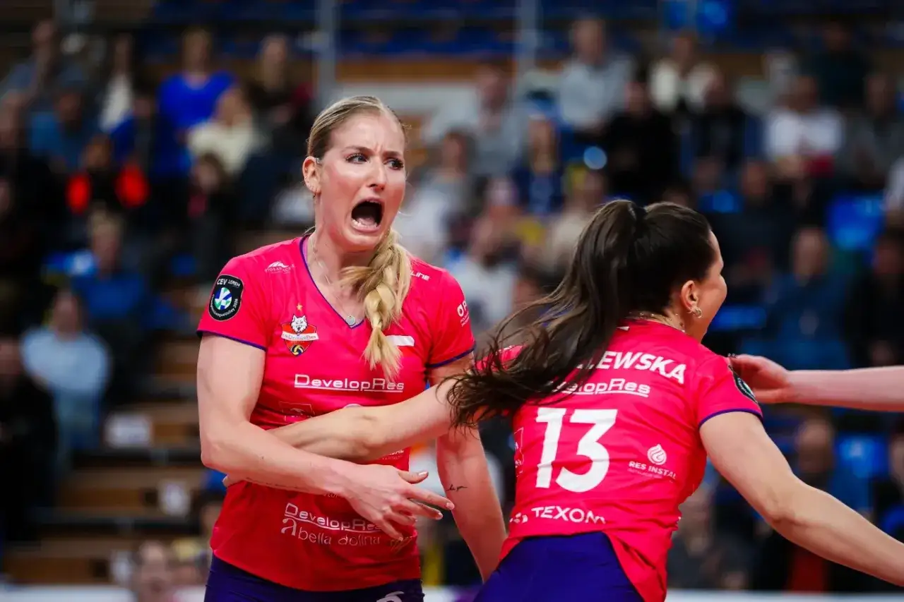 Emocje na parkiecie podczas meczu siatkówki w ramach Ligi Mistrzyń. Zawodniczka krzyczy z wysiłku, druga z numerem 13 na plecach reaguje.
