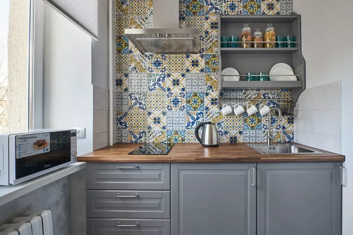 Inspirujące, jakie płytki do kuchni na ścianę! Wzorzyste, wielobarwne kafle w stylu patchwork tworzą efektowną mozaikę nad blatem.