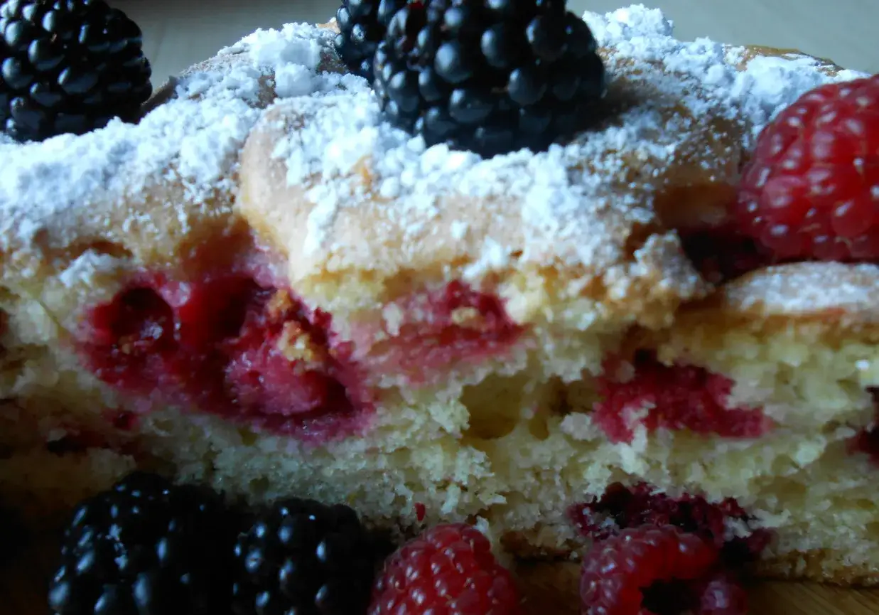 Pyszne ciasta z owocami, posypane cukrem pudrem, z malinami i jeżynami. Idealne na letnie popołudnie.