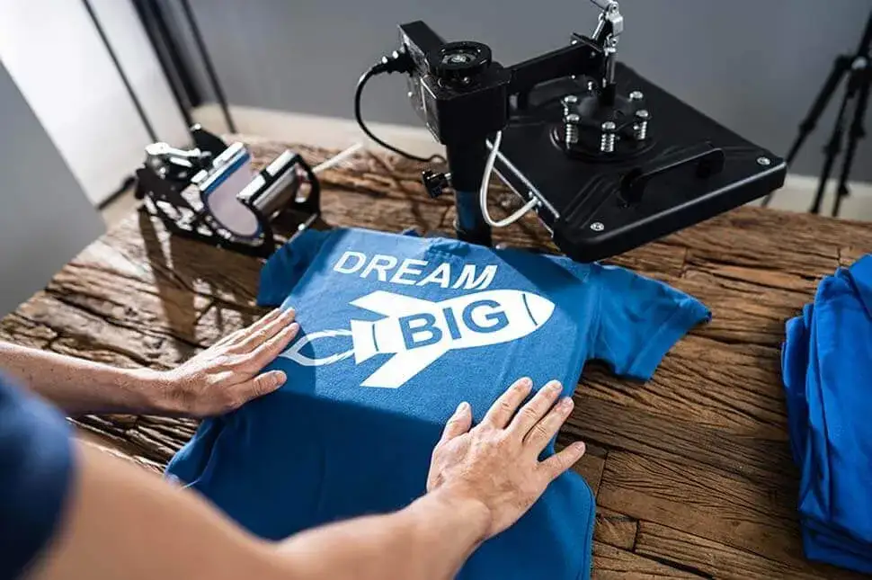 Person bedruckt ein T-Shirt mit einer Transferpresse