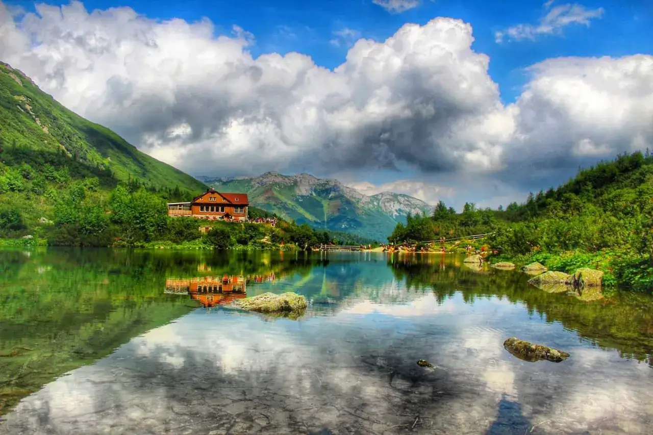 Słowacja g&oacute;ry gdzie jechać? Jezioro z odbiciem chatki i g&oacute;r. Idealne miejsce na wakacje.