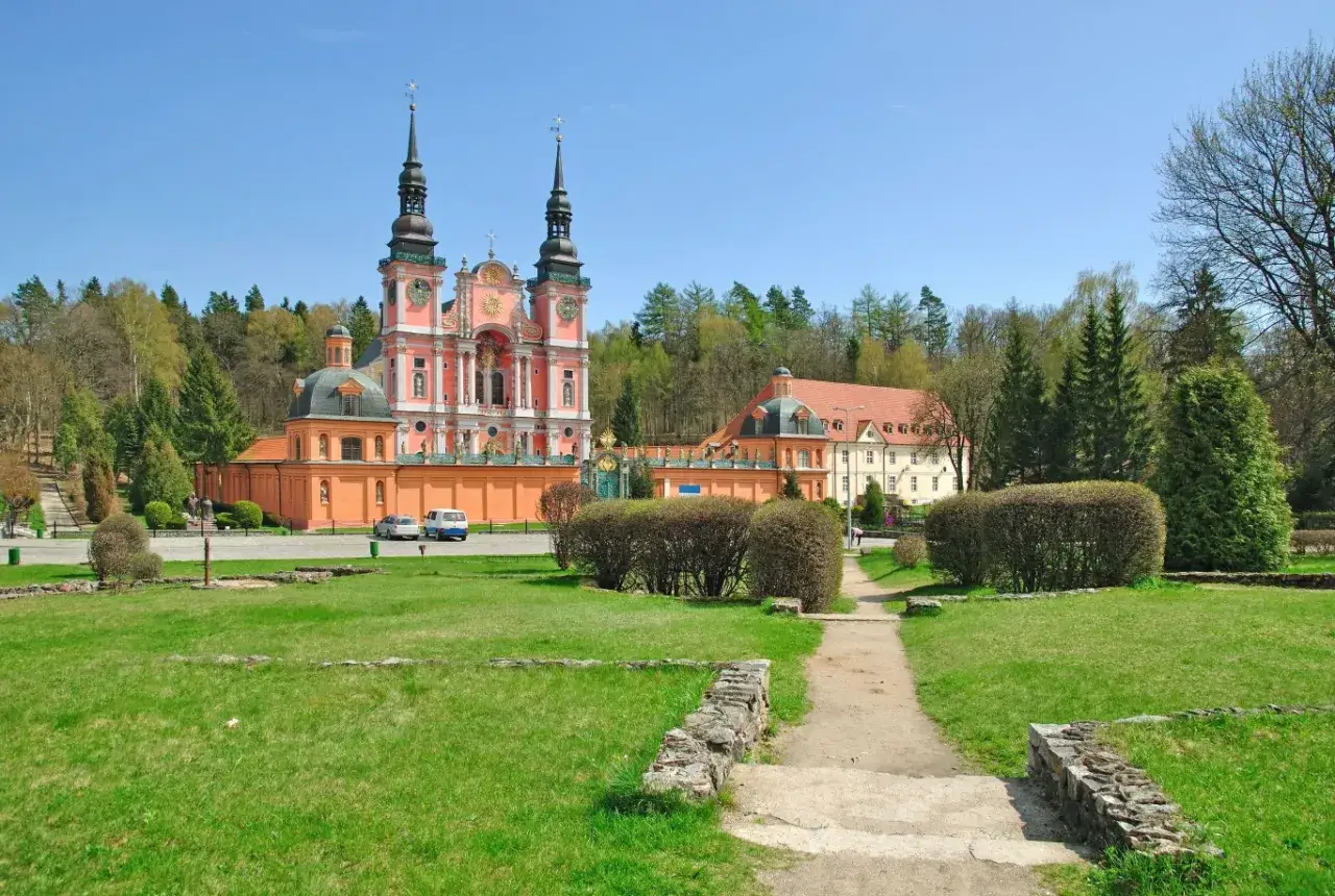 Barokowy klasztor w otoczeniu zieleni, jeden z najciekawszych miejsc świętych w Polsce ukrytych w małych wioskach.