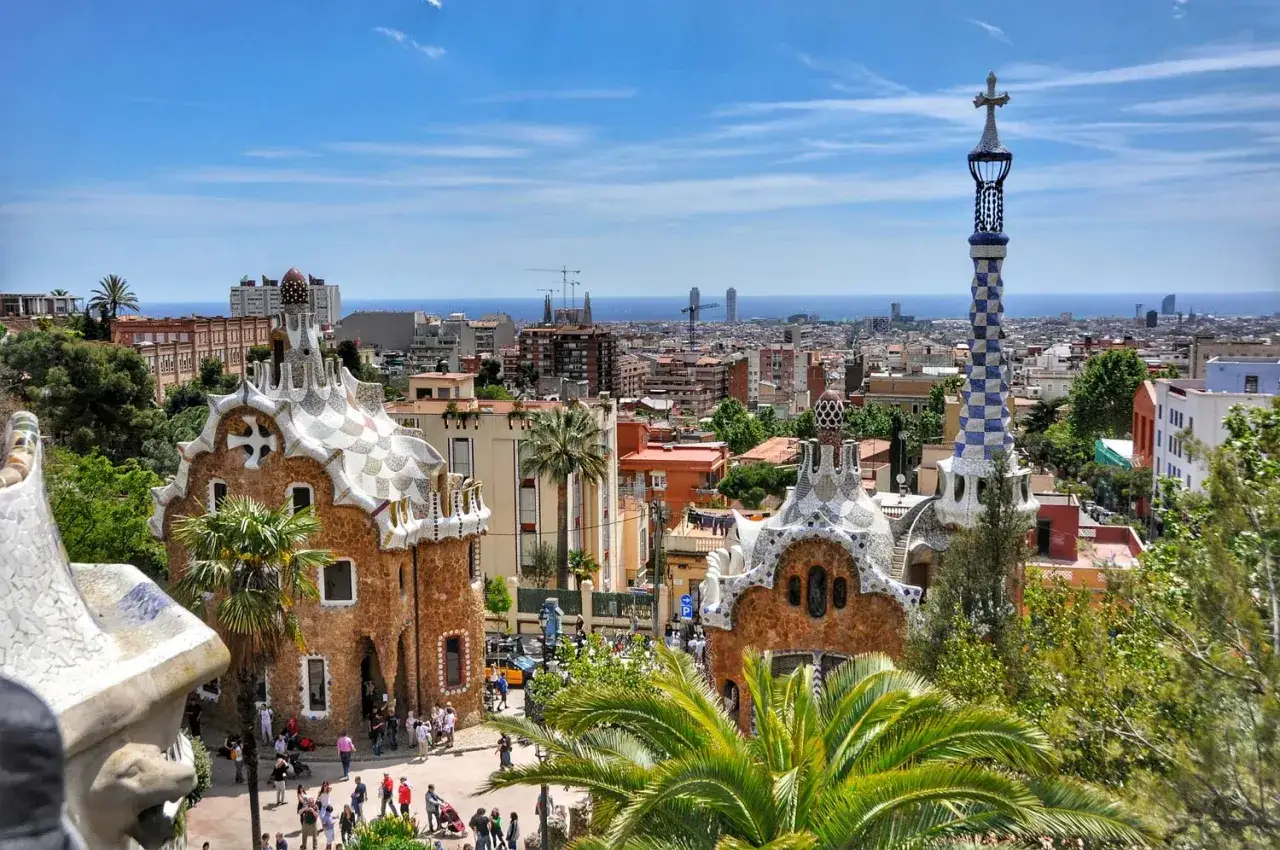 Park G&uuml;ell w Barcelonie, idealne miejsce na nocleg. Widok na miasto i morze z mozaikowymi budynkami.